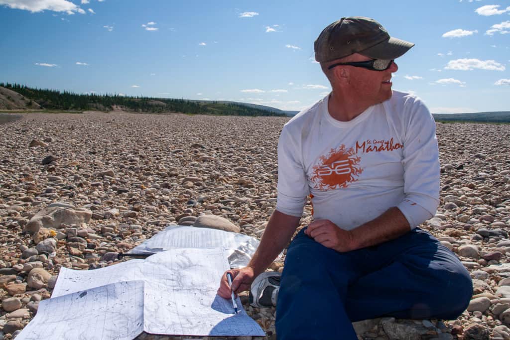 Looking at a map on the bank of the Horton River