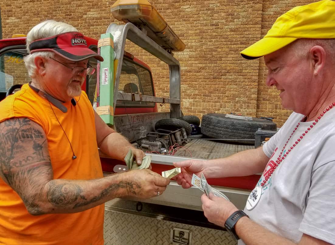 Matt being handed the money from the tow truck driver