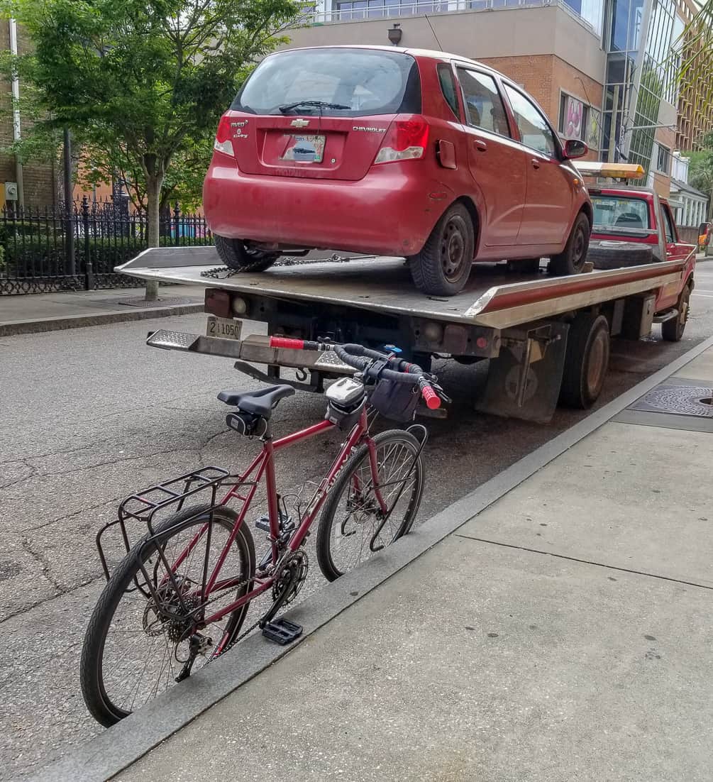 Car parked on the tow truck with the bike in the foreground