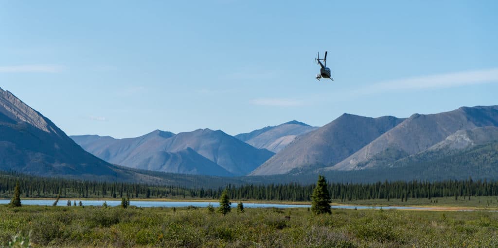 Helicopter taking off from Canol Outfitters on the Canol Heritage Trail