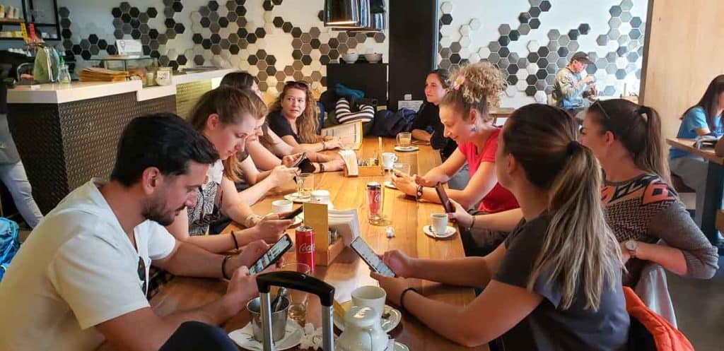 Picture of people sitting at a table looking at their phones