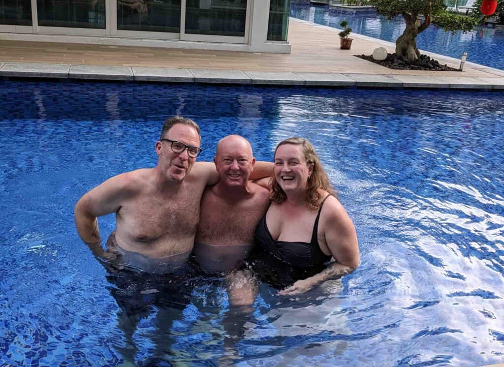 Three people standing in a swimming pool