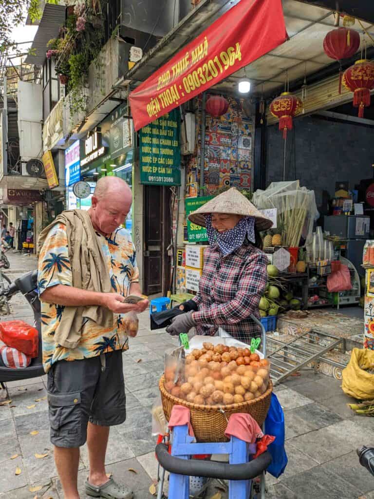 man buying something from a street vendor