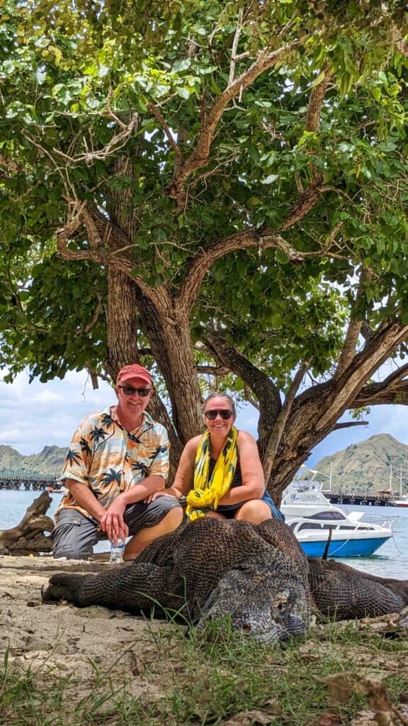 Two people behind a Komodo Dragon