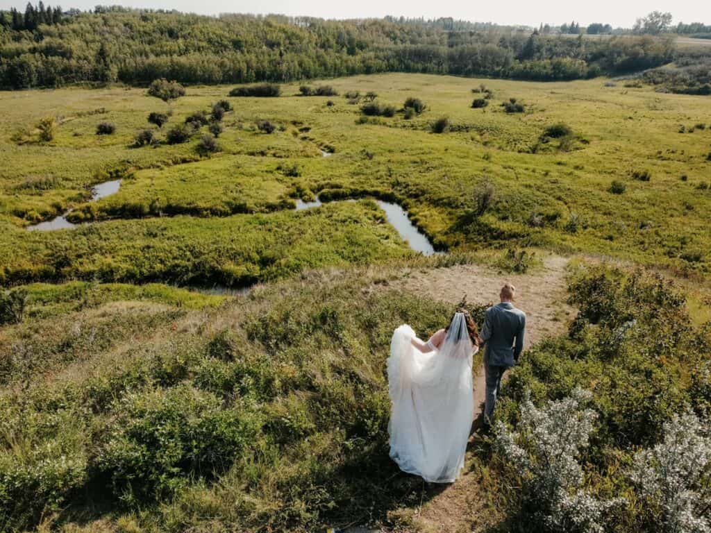 Bride and Groom walking in the prairie